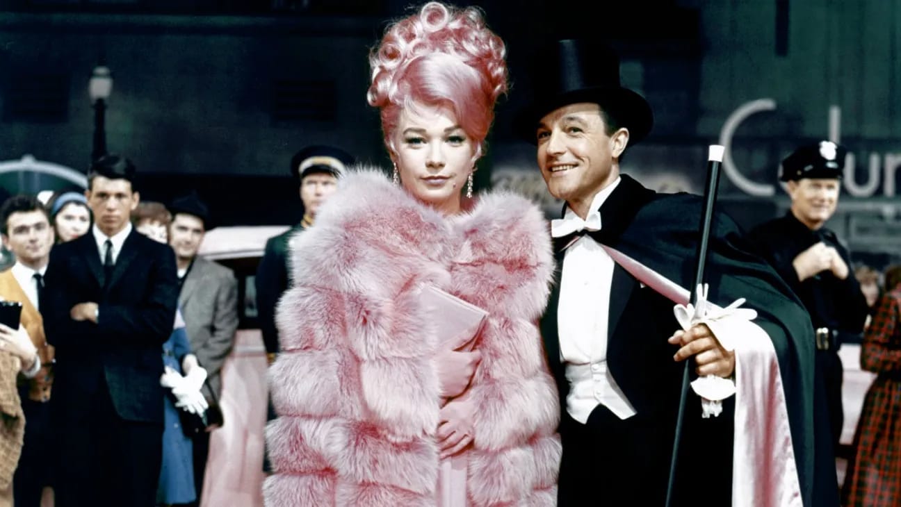 Shirley MacLaine in a stunning all-pink gown, fur coat, and wig