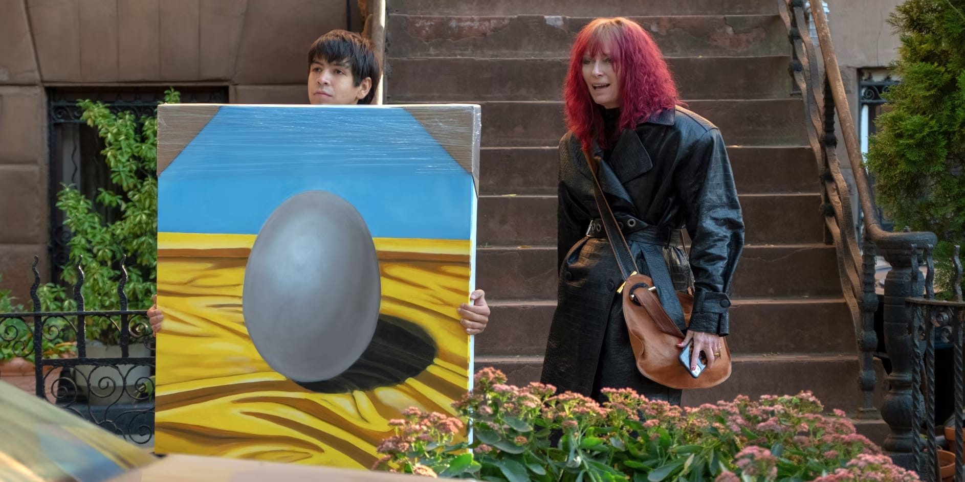 Julio Torres and Tilda Swinton and a giant painting of an egg in the movie Problemista