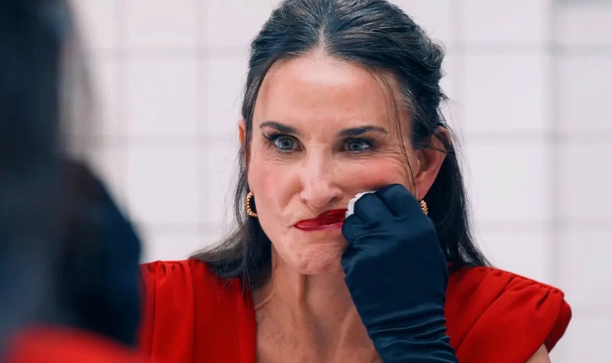 Demi Moore furiously wiping off makeup in a scene from The Substance