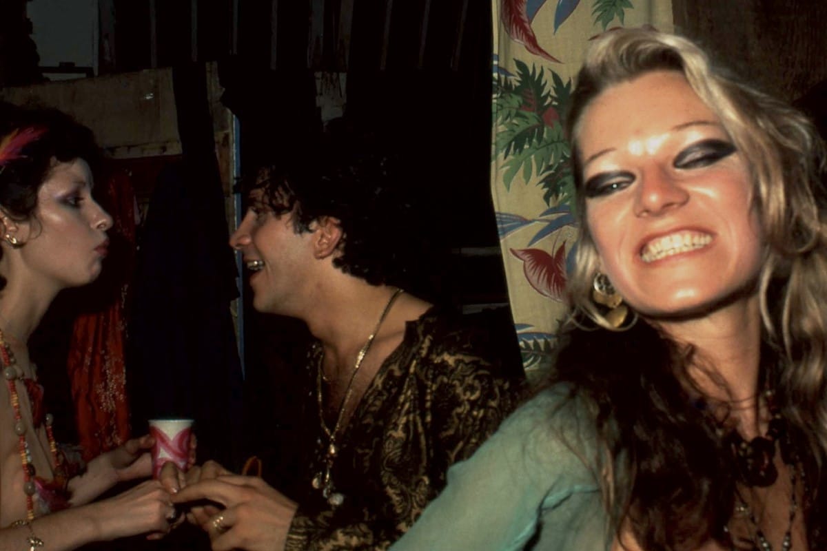 Cookie Mueller, smiling at the camera at some sort of fabulous party I wish I was able to go to