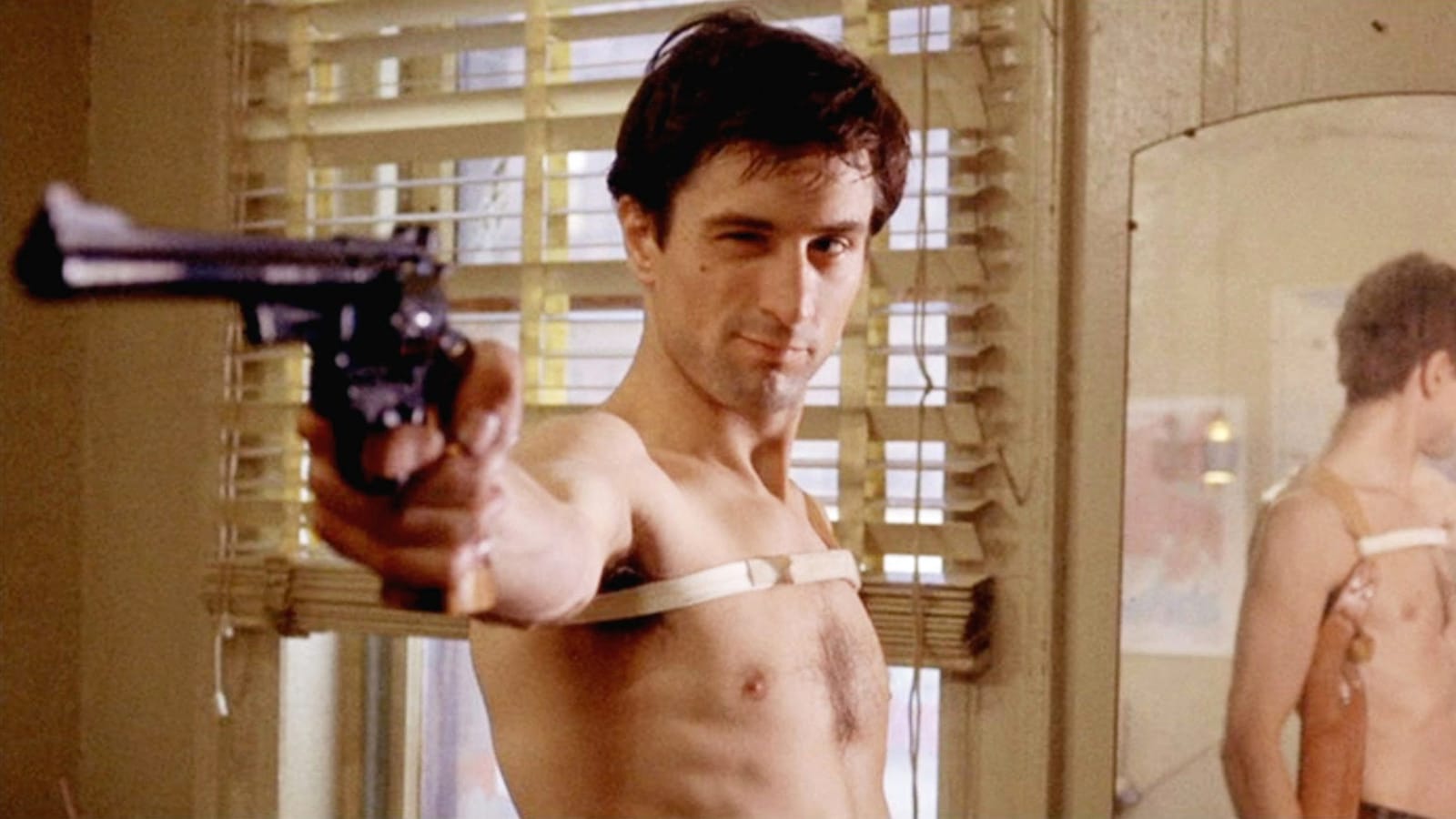 Robert De Niro aiming a gun at the mirror in Taxi Driver