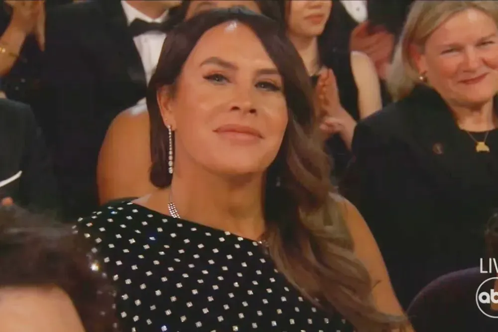 Karla Sofia Gascon smiling at the cameras in a still from the Oscars