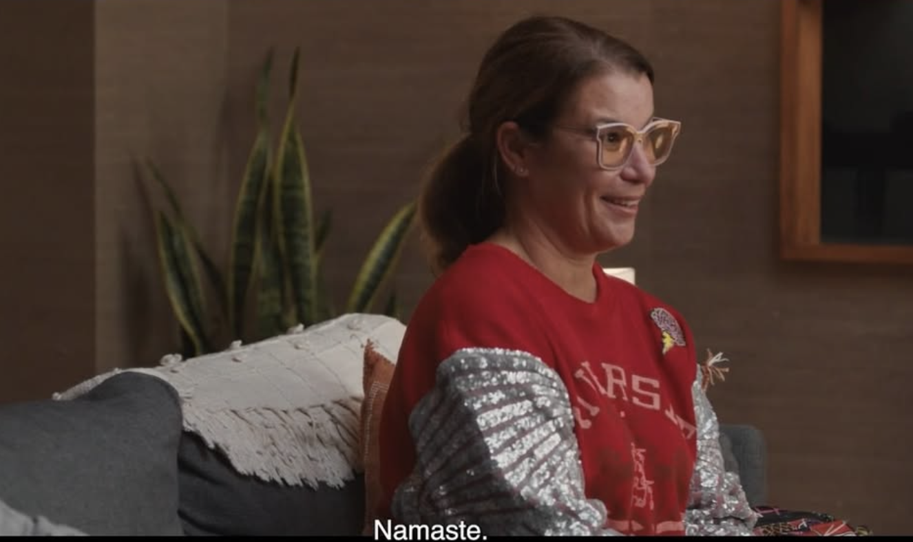 A screenshot of the latest season of Couple's Therapy, showing Alison with her signature very sparkly sleeves and crazy glasses, saying "Namaste"
